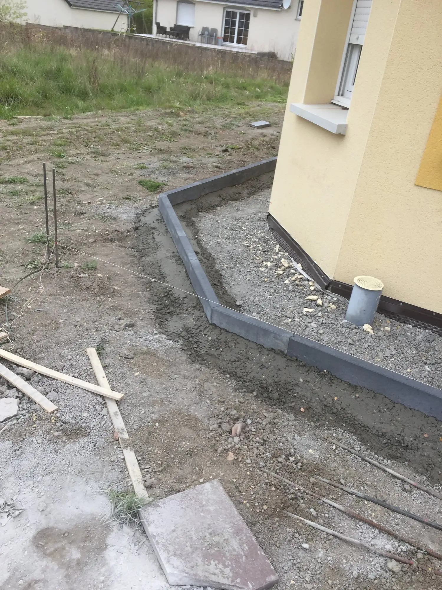 Terrassement en cours avec fondation et bordures avant la pose d’un revêtement
